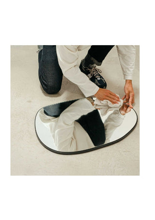 A man polishing a mirror with Attirecare Clean Home Spray