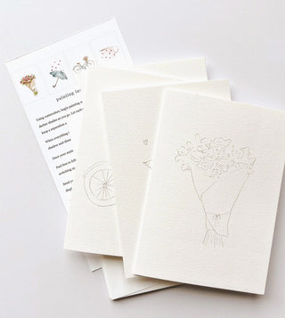 Set of white greeting cards with floral illustrations on a light gray background