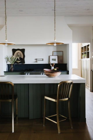 Kitchen  featuring the bench island with brass coloured stool.