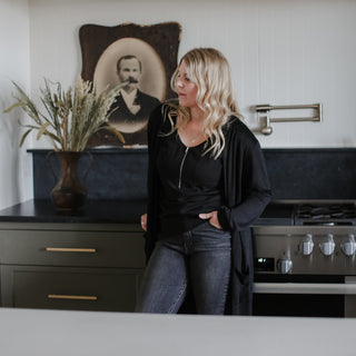 Farmer's Daughter Homestead Founder & Owner, Kelsey Grose in front of a stove at her Wildwood design project