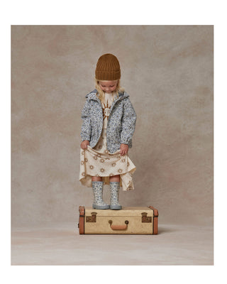 Little girl standing on a suitcase wearing Rylee & Cru Little Girl's Raincoat in Georgia Blue Floral