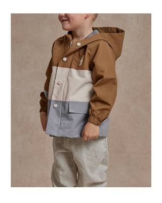 Little boy standing on the side wearing a Rylee & Cru's Boy's Raincoat with color blocking