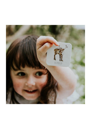 Little girl holding up a card from the modern monty christmas memory game