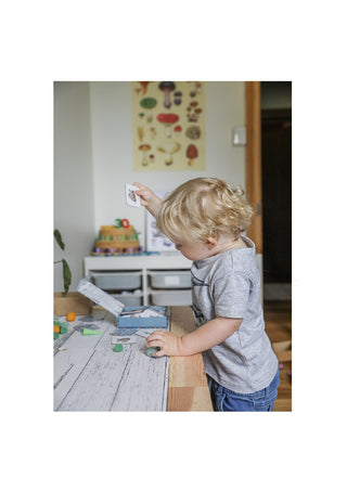 Little boy playing with Modern Monty's Ocean Memory Card Game on a table