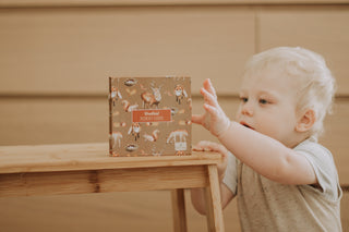 A child reaching out for Modern Monty's Woodland Memory Card Game
